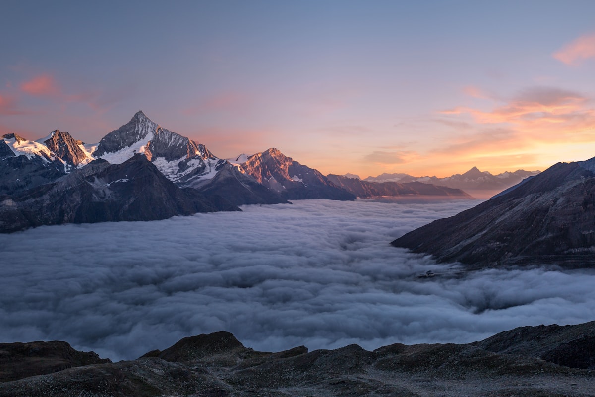 Snow-capped Alpine peaks above green valleys